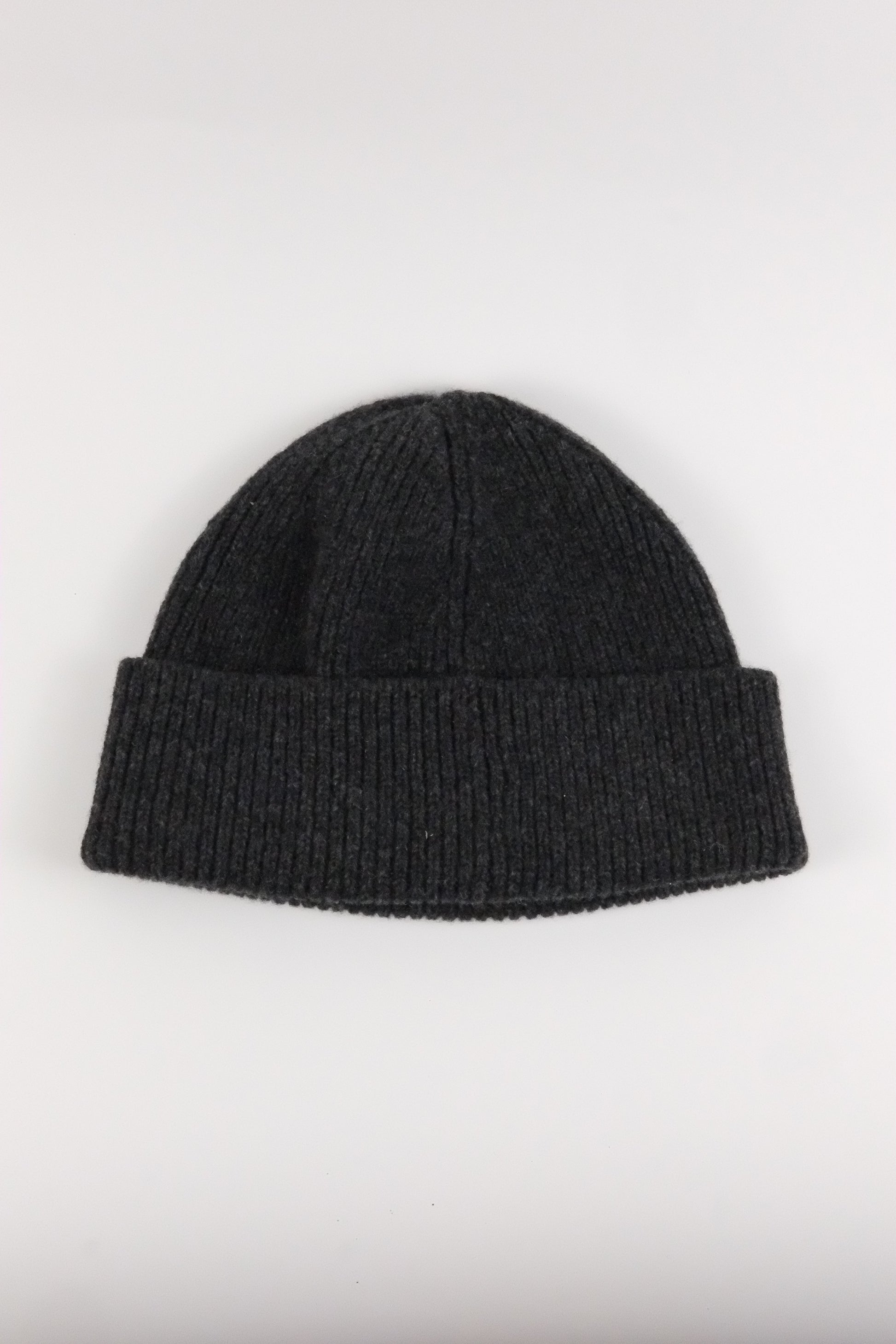 Black knit beanie on a light gray background