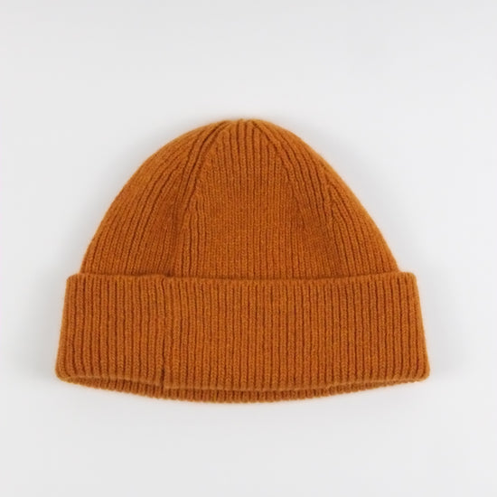 orange knit beanie on a white background