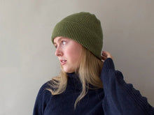 Load image into Gallery viewer, Person wearing a green knit beanie and navy sweater against a plain background
