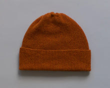 Load image into Gallery viewer, Orange knit beanie on a grey background
