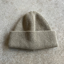 Load image into Gallery viewer, Gray knit beanie on a textured grey surface
