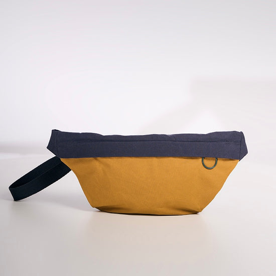 Two-toned waist bag with black top and brown bottom on a white background