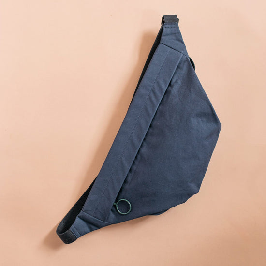 Navy blue sling bag on a beige background