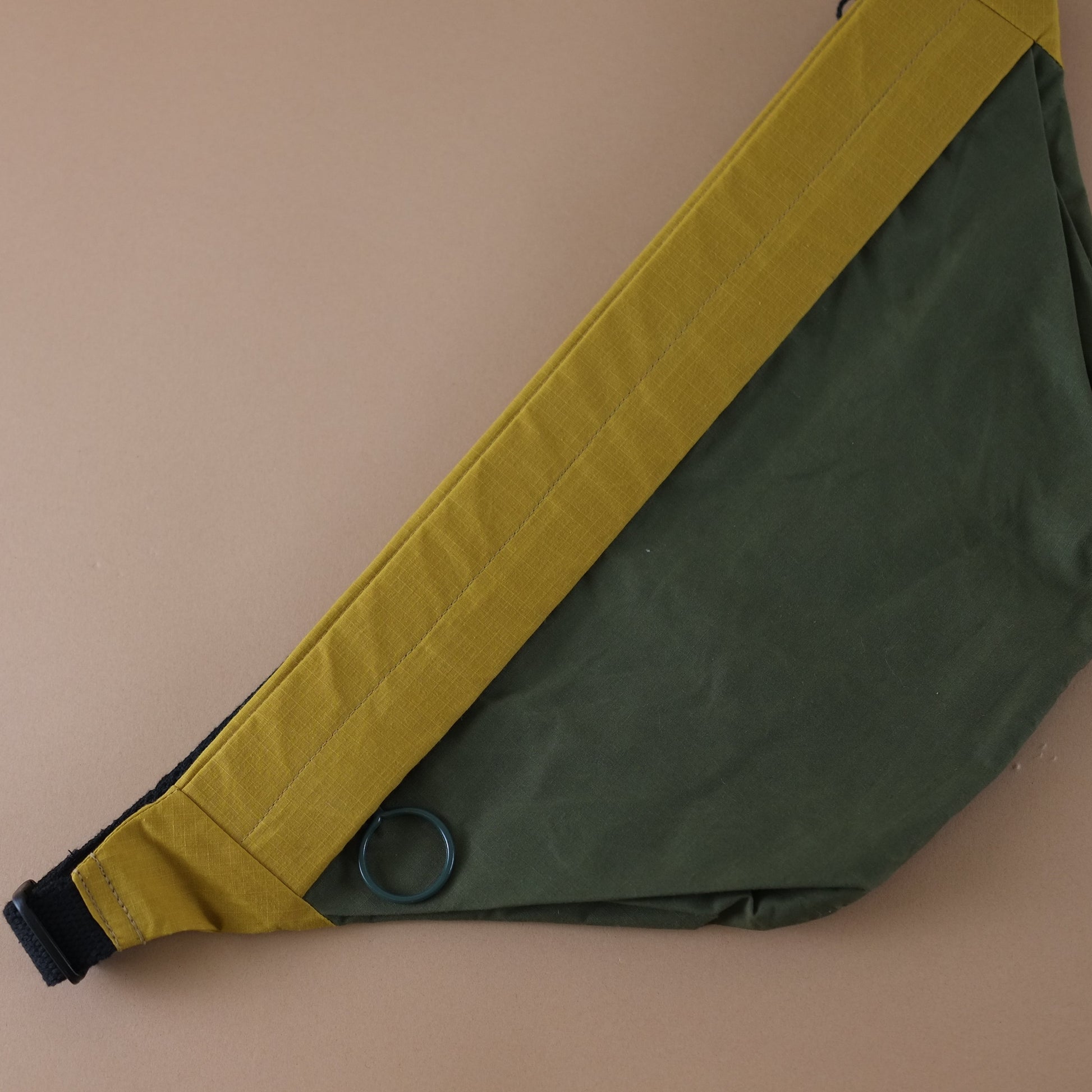 Green and yellow crossbody bag on a beige background