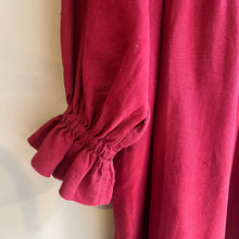 Load image into Gallery viewer, Close-up of a red garment with puffed sleeves on a neutral background

