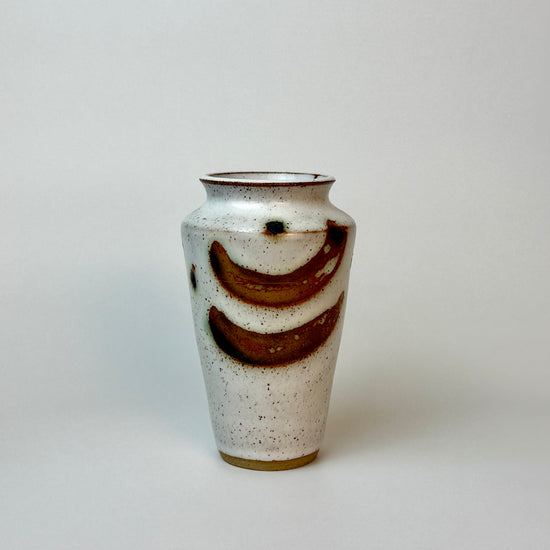 Ceramic vase with brown accents on a light gray background