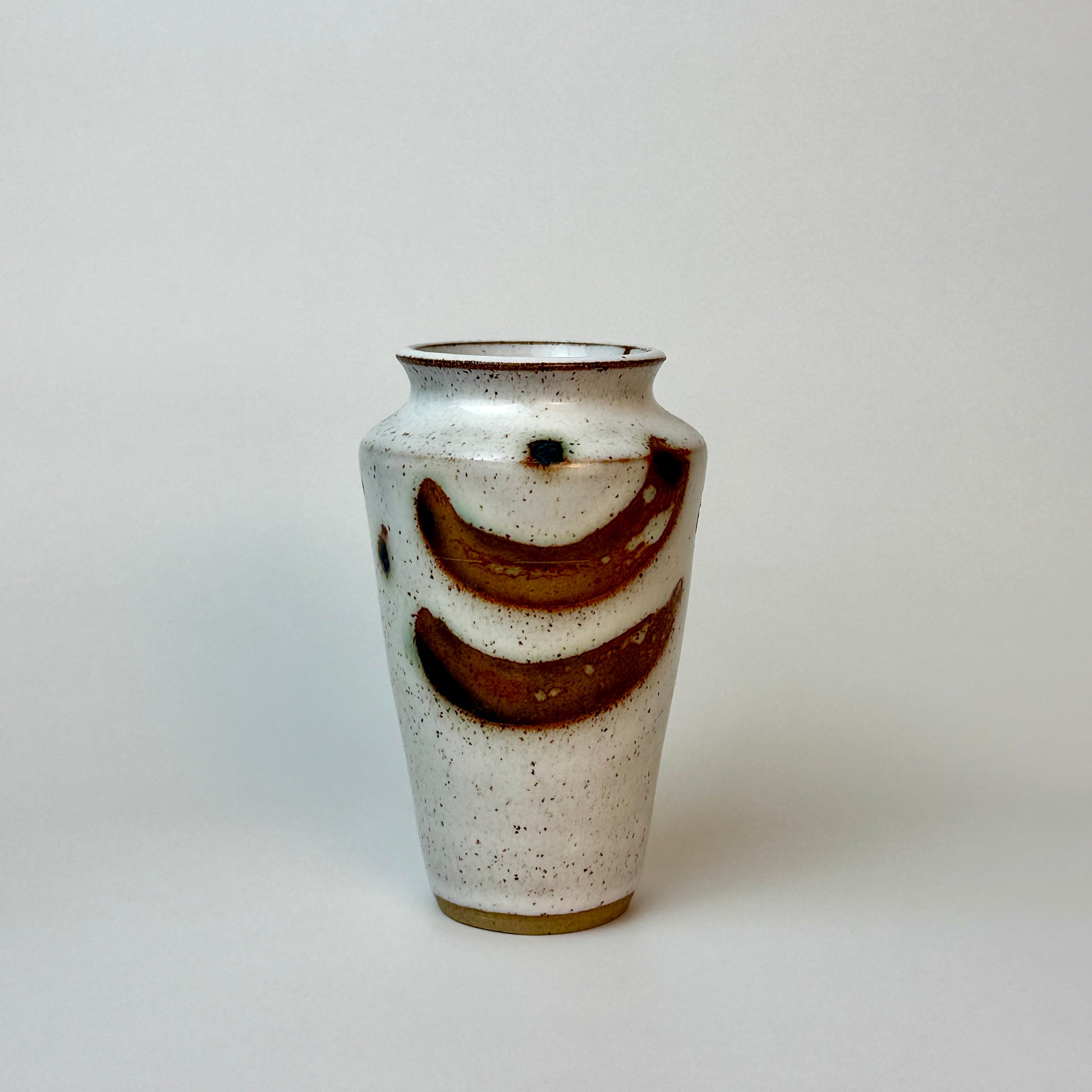 Ceramic vase with brown accents on a light gray background