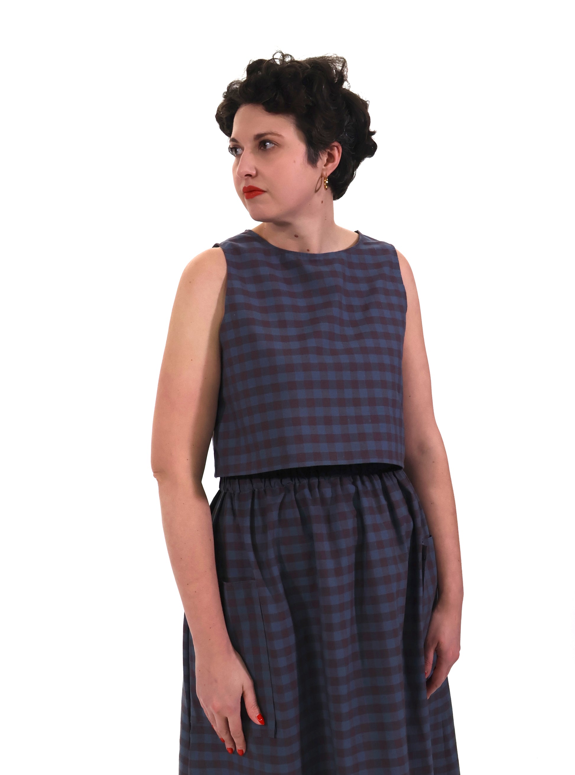 model wears plum and navy check cotton top and skirt on a white background