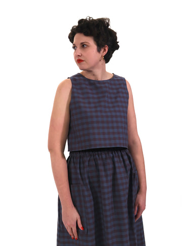 model wears plum and navy check cotton top and skirt on a white background
