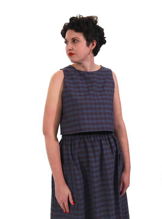model wears plum and navy check cotton top and skirt on a white background