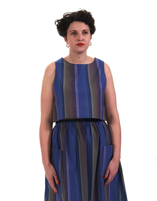 Model wearing blue and lilac stripe cropped tank top with matching gathered skirt in front of a white background