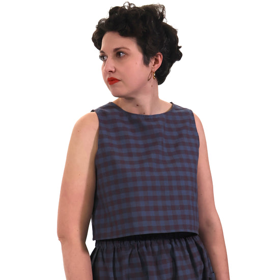 Woman wearing a blue plaid dress on a white background
