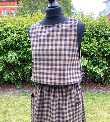 Black and khaki top and skirt on a mannequin against a green outdoor background