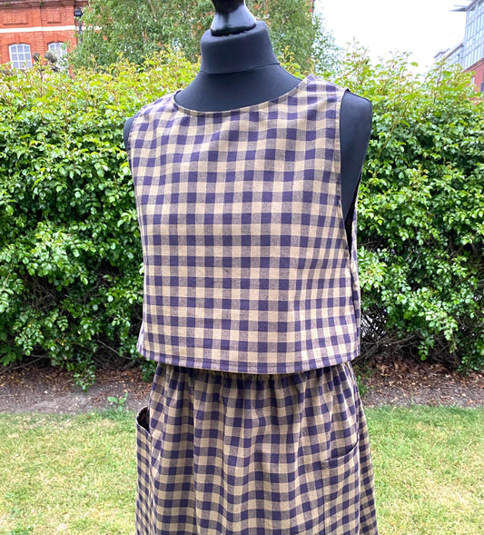 Black and khaki top and skirt on a mannequin against a green outdoor background