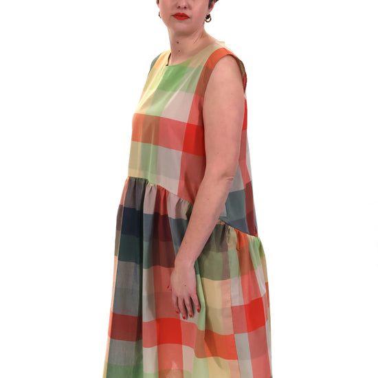 Woman wearing a colorful checkered dress on a white background
