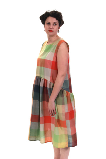 Woman wearing a colorful checkered dress on a white background