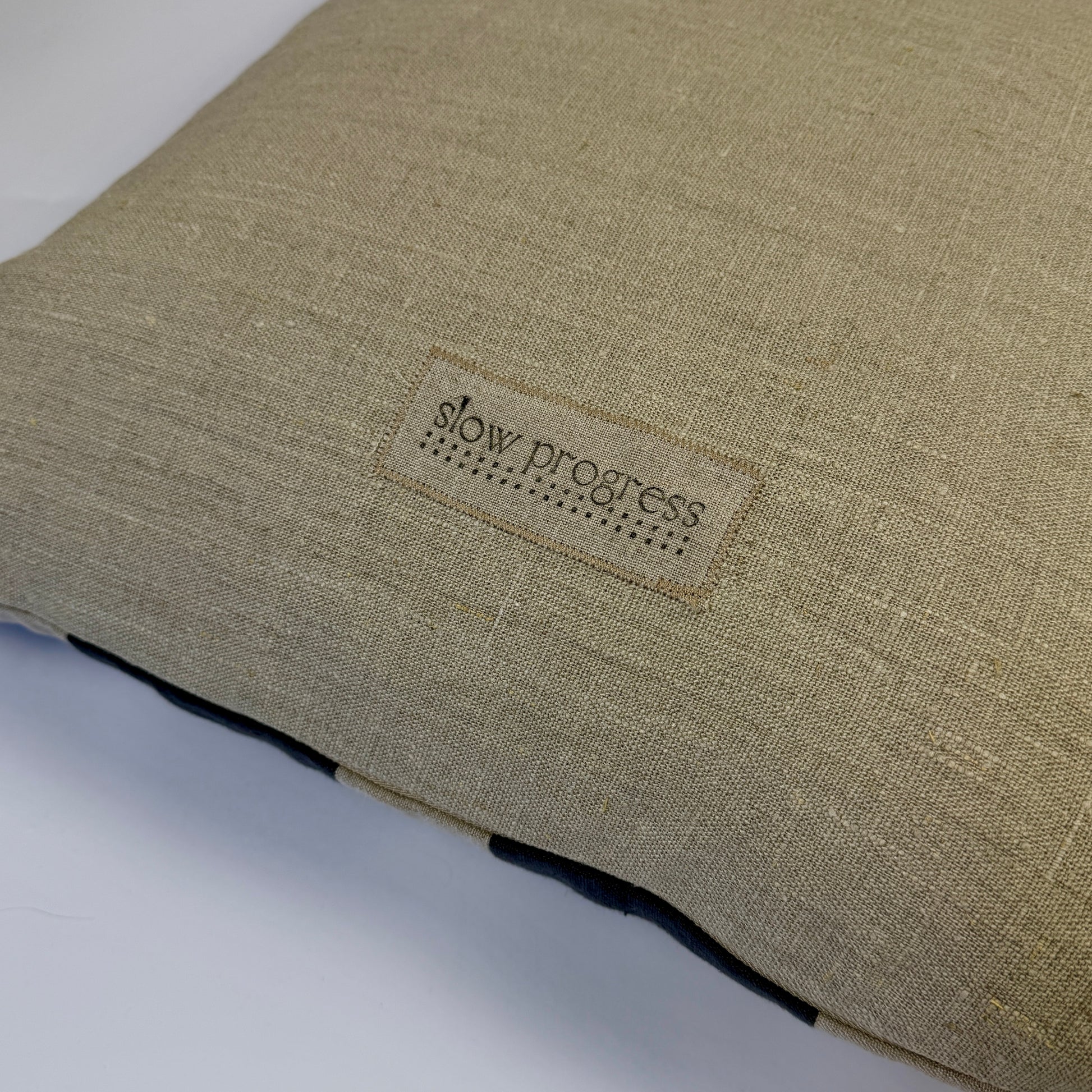 Textile product with 'slow progress' label on a plain background