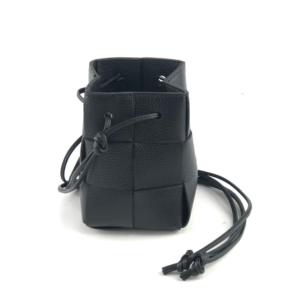 A black woven leather handbag on a white background 