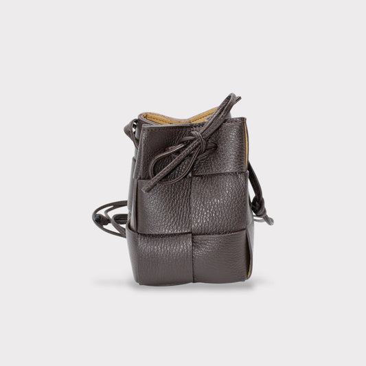 a brown woven leather handbag on a white background 