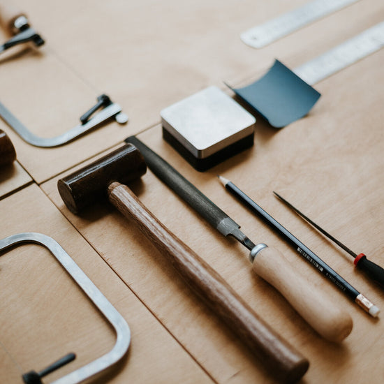 Set of tools including a hammer, saw,  on a wooden surface