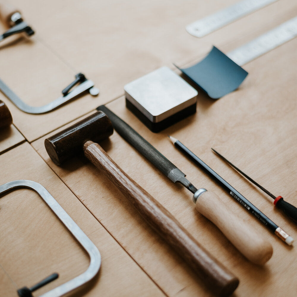 Set of tools including a hammer, saw,  on a wooden surface