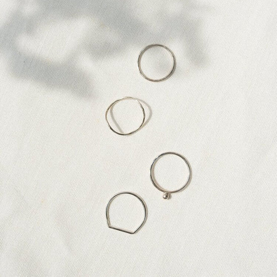 Four silver rings on a white backround 