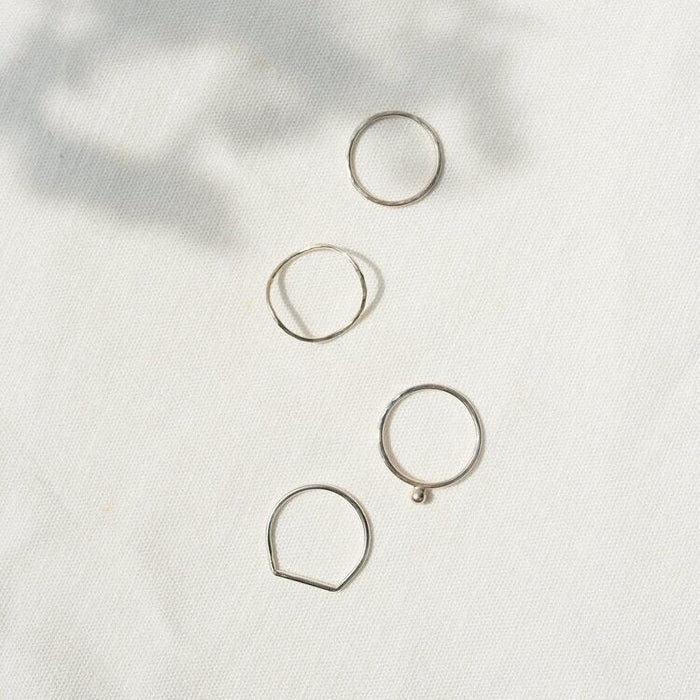 Four silver rings on a white backround 