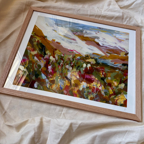 Framed abstract painting on a beige fabric background