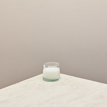 Load image into Gallery viewer, A low jug filled with milk on a taupe background 
