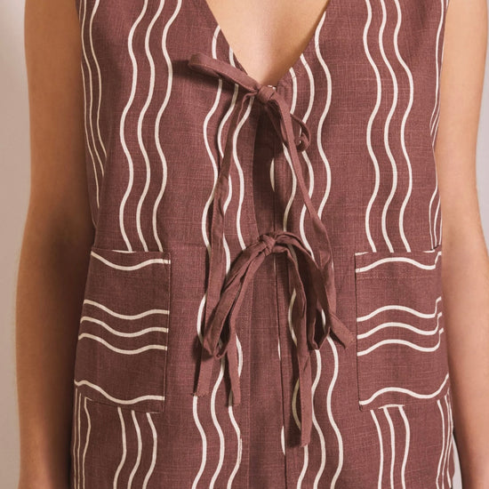 Brown sleeveless top with white wavy pattern on a plain background