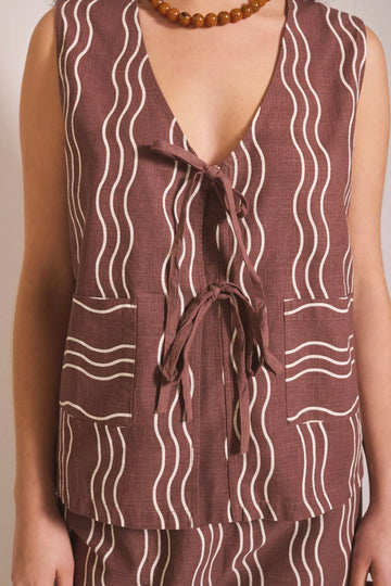 Brown sleeveless top with white wavy pattern on a plain background