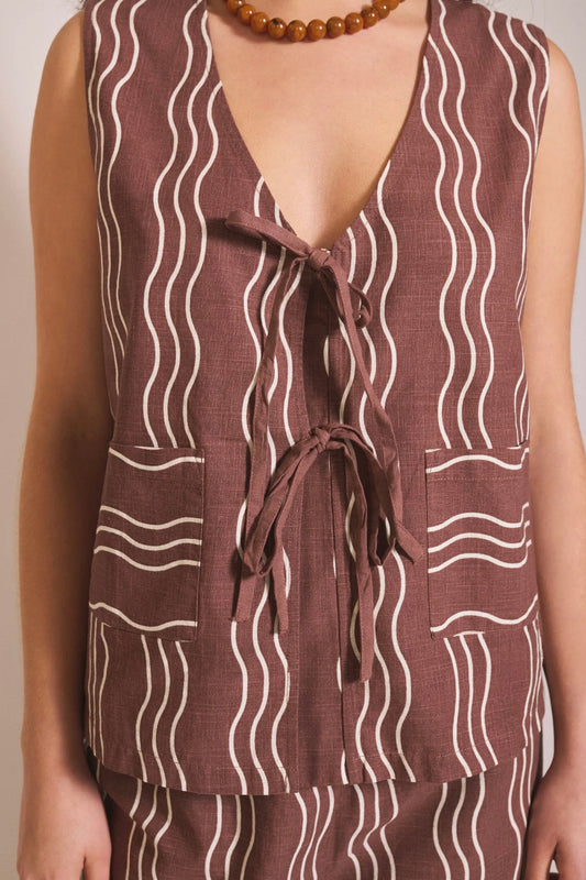 Brown sleeveless top with white wavy pattern on a plain background