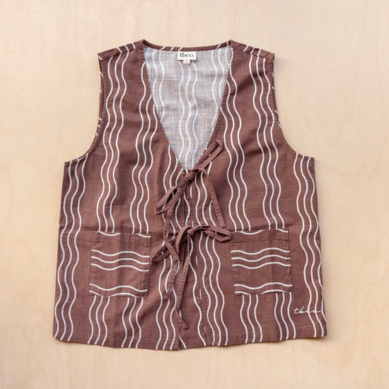 Brown patterned vest with white stripes on a beige background
