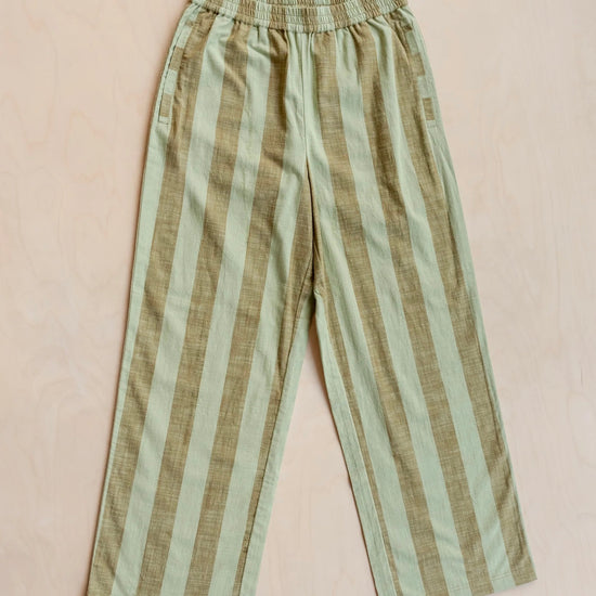 Striped trousers with green and brown pattern on a beige background