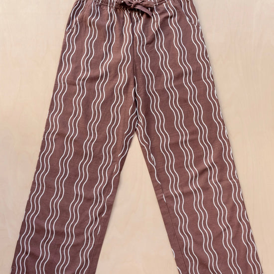 Brown trousers with white wavy lines on a beige background