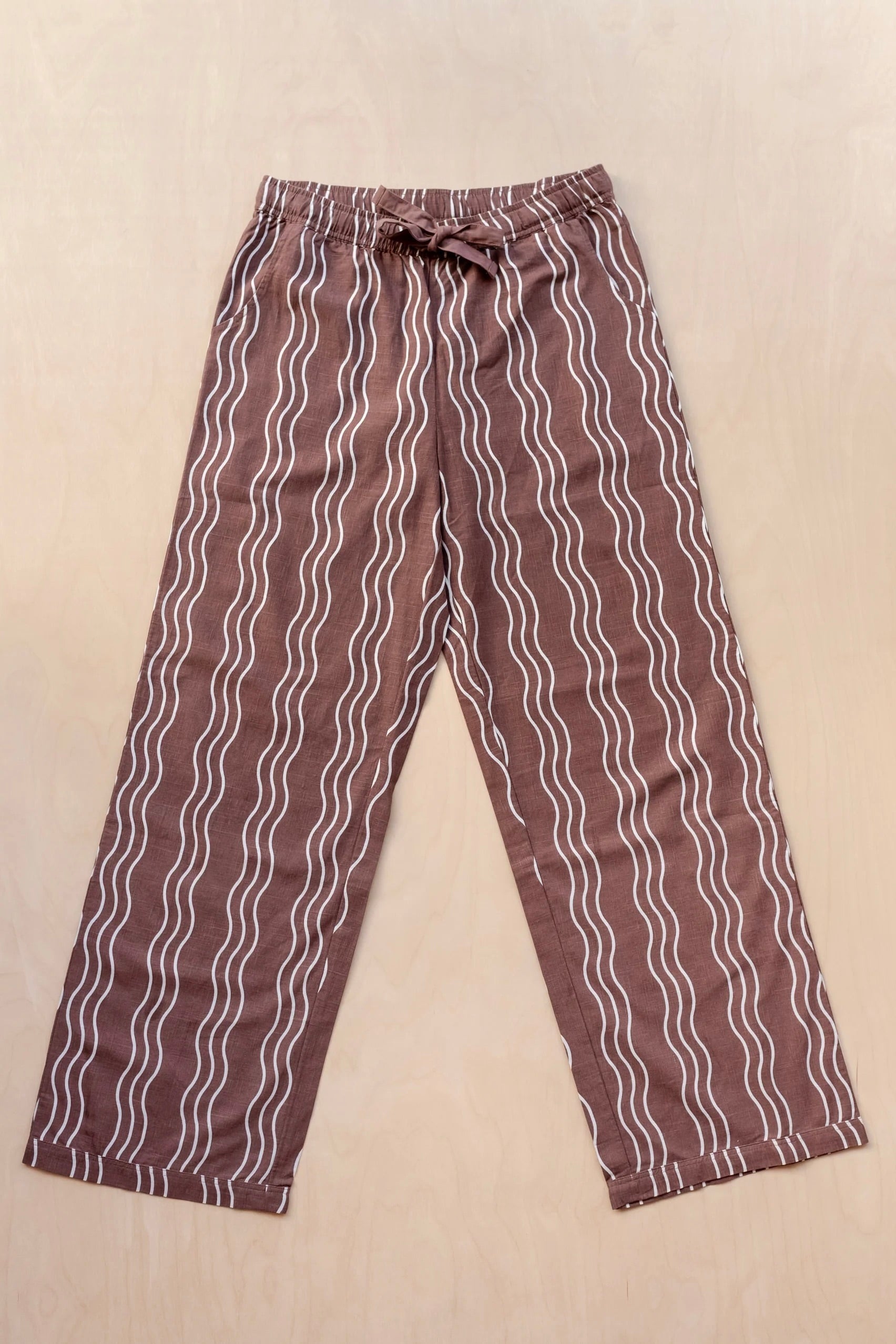 Brown trousers with white wavy lines on a beige background