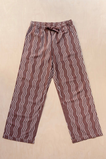 Brown trousers with white wavy lines on a beige background