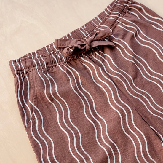 Brown trousers with white wavy lines on a beige background