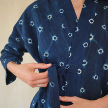 Load image into Gallery viewer, Person wearing a blue robe with white patterns on a beige background
