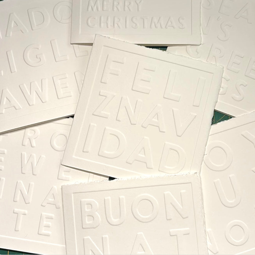 White greeting cards with embossed text on a white background
