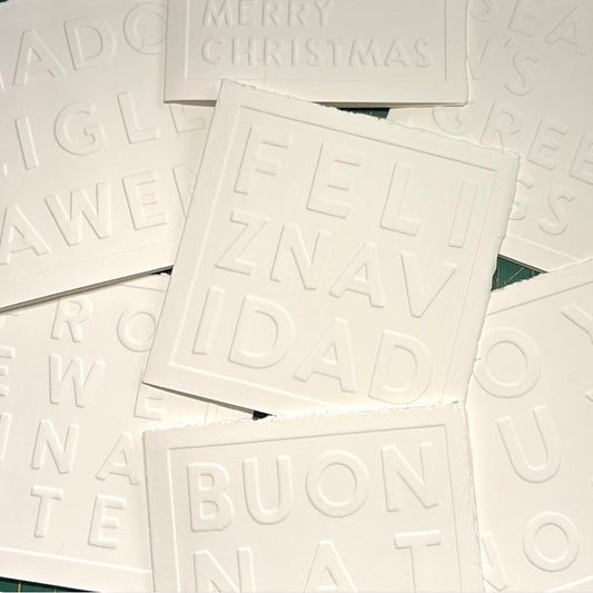 White greeting cards with embossed text on a white background