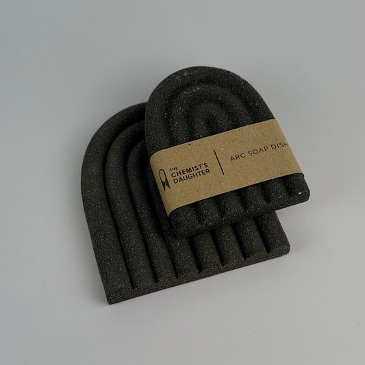 Set of black soap dishes with a branded label on a gray background