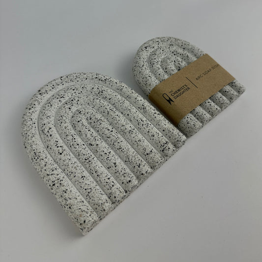 Speckled gray and white beanie with a brown label on a light gray background