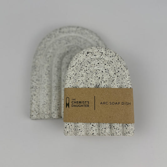 Speckled soap dish with a brown label on a gray background