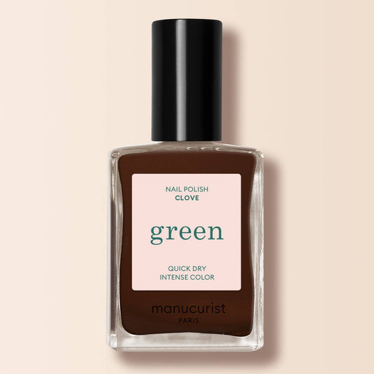 a brown nail varnish in a bottle on a cream background 