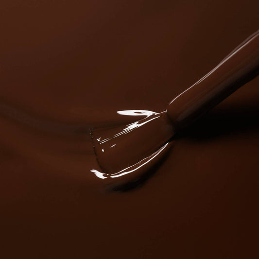 A brown nail varnish with a brush in situ 