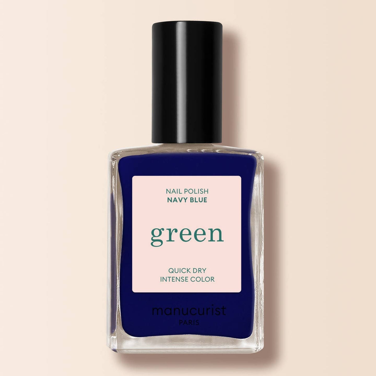a navy blue nail varnish in a bottle on a cream background 