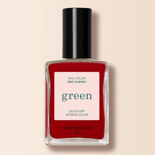 A red nail varnish bottle on a cream background