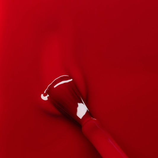 red liquid nail varnish with a brush in situ 