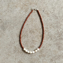 Load image into Gallery viewer, Pearl and seed bead necklace in brick on a beige background
